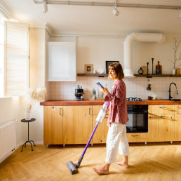 Woman,Vacuuming,Floor,With,A,Cordless,Hand,Vacuum,Cleaner,In