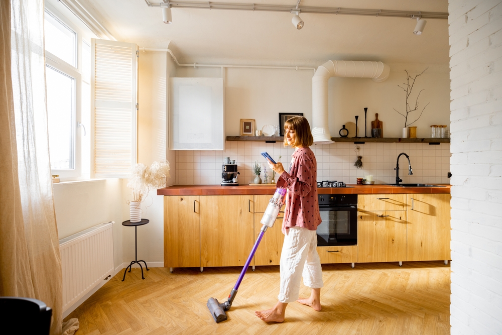 Woman,Vacuuming,Floor,With,A,Cordless,Hand,Vacuum,Cleaner,In